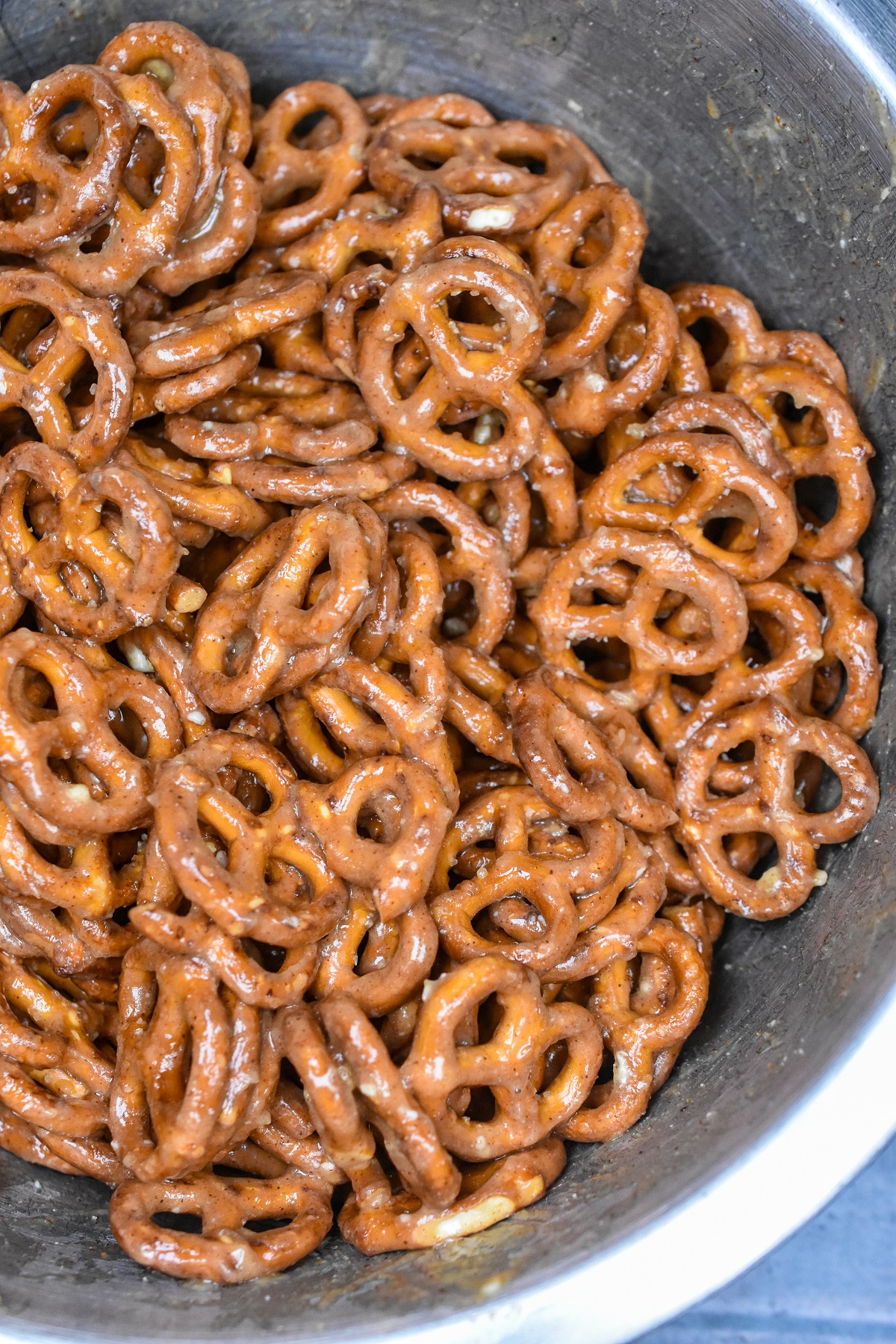 Sweet & Spicy Butter Toffee Pretzels shown being mixed in a steel bowl.