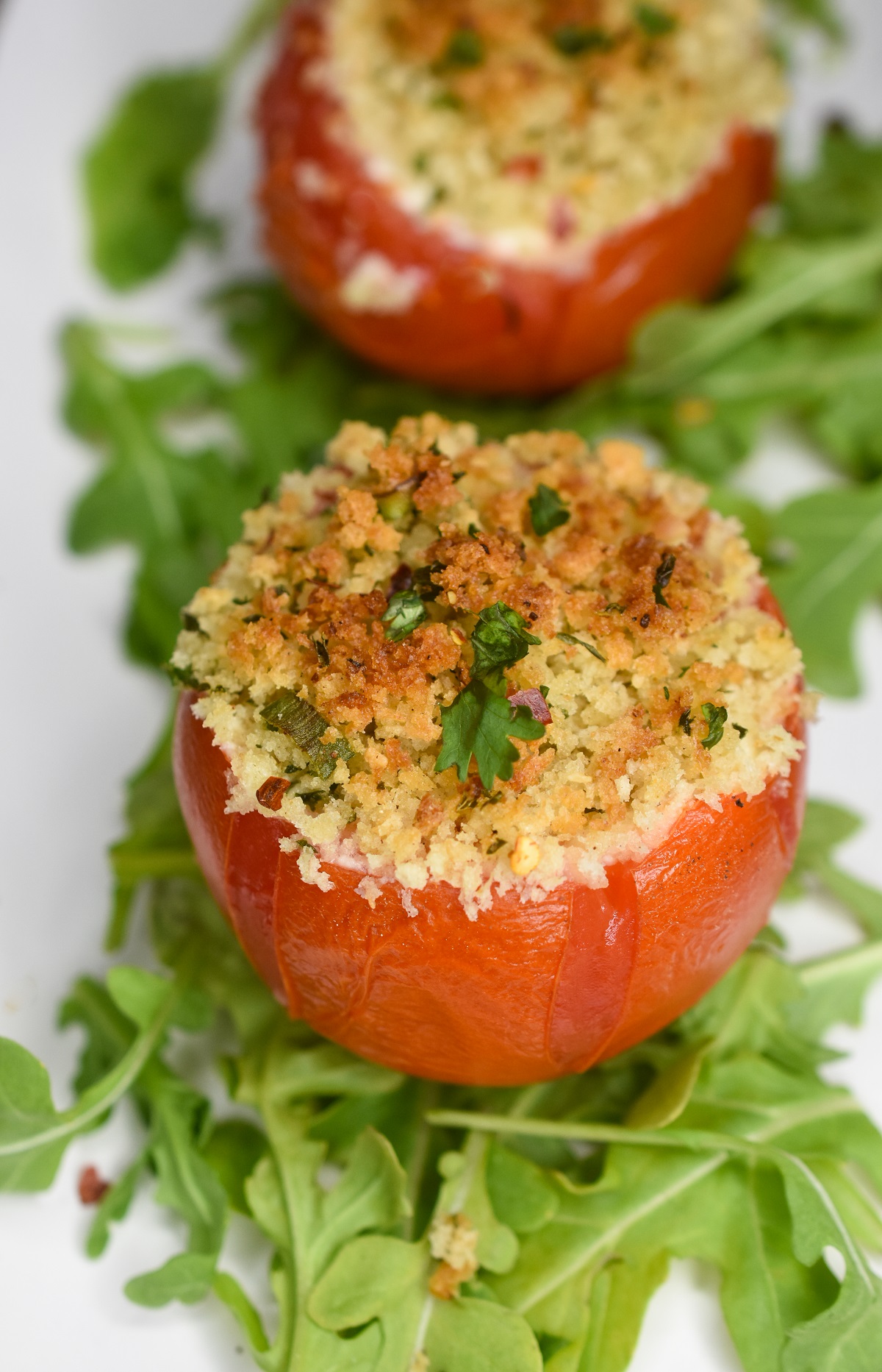 Stuffed Tomatoes Recipe Baked tomatoes stuffed with cheese topped with breadcrumbs. over arugula.