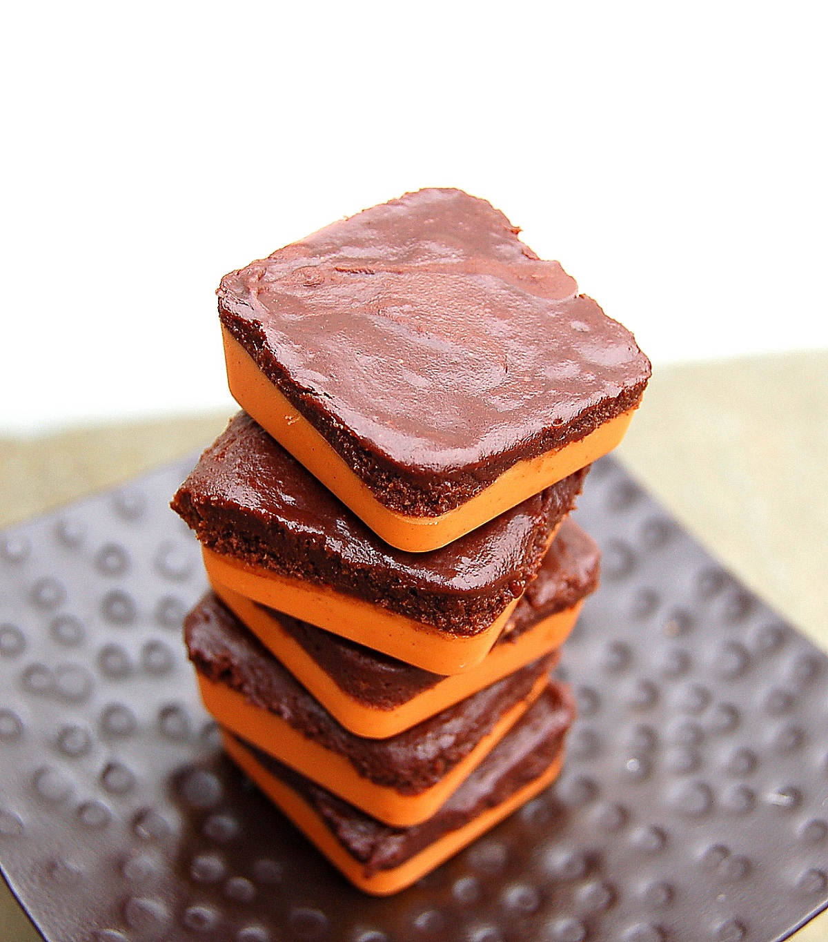 Fun Halloween Chocolate and Peanut Butter Candy. A Halloween craft the kids can help with and then eat or gift. Shown as orange and black candy piled atop one another.