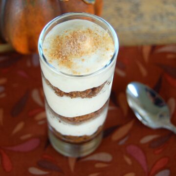 Mini Thanksgiving Dessert reciper. SHown Pumpkin Pie Shoorters recipe. In small glass with spoon. Pumpkin cheesecake and graham cracker crumb layers.