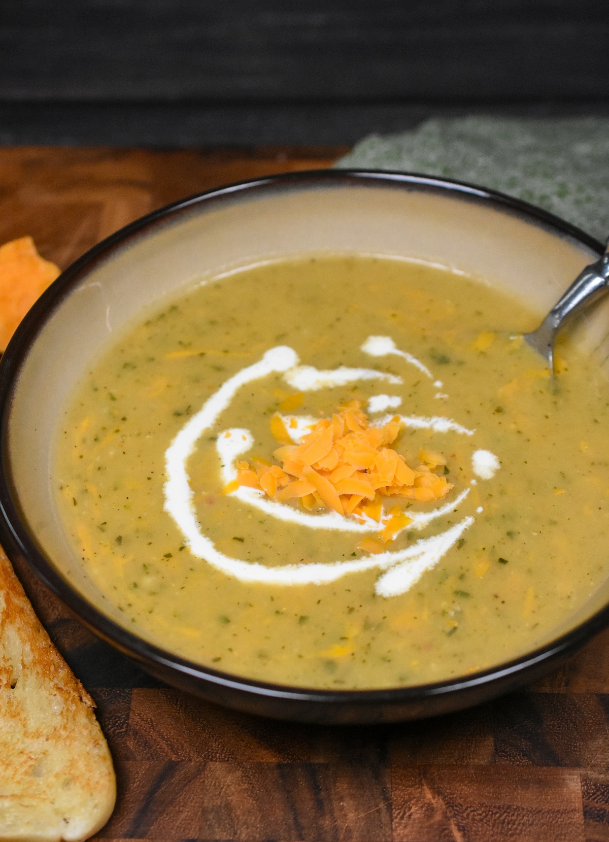 Roasted Zucchini Soup with cheese in a low flat bowl with a swirl of cream