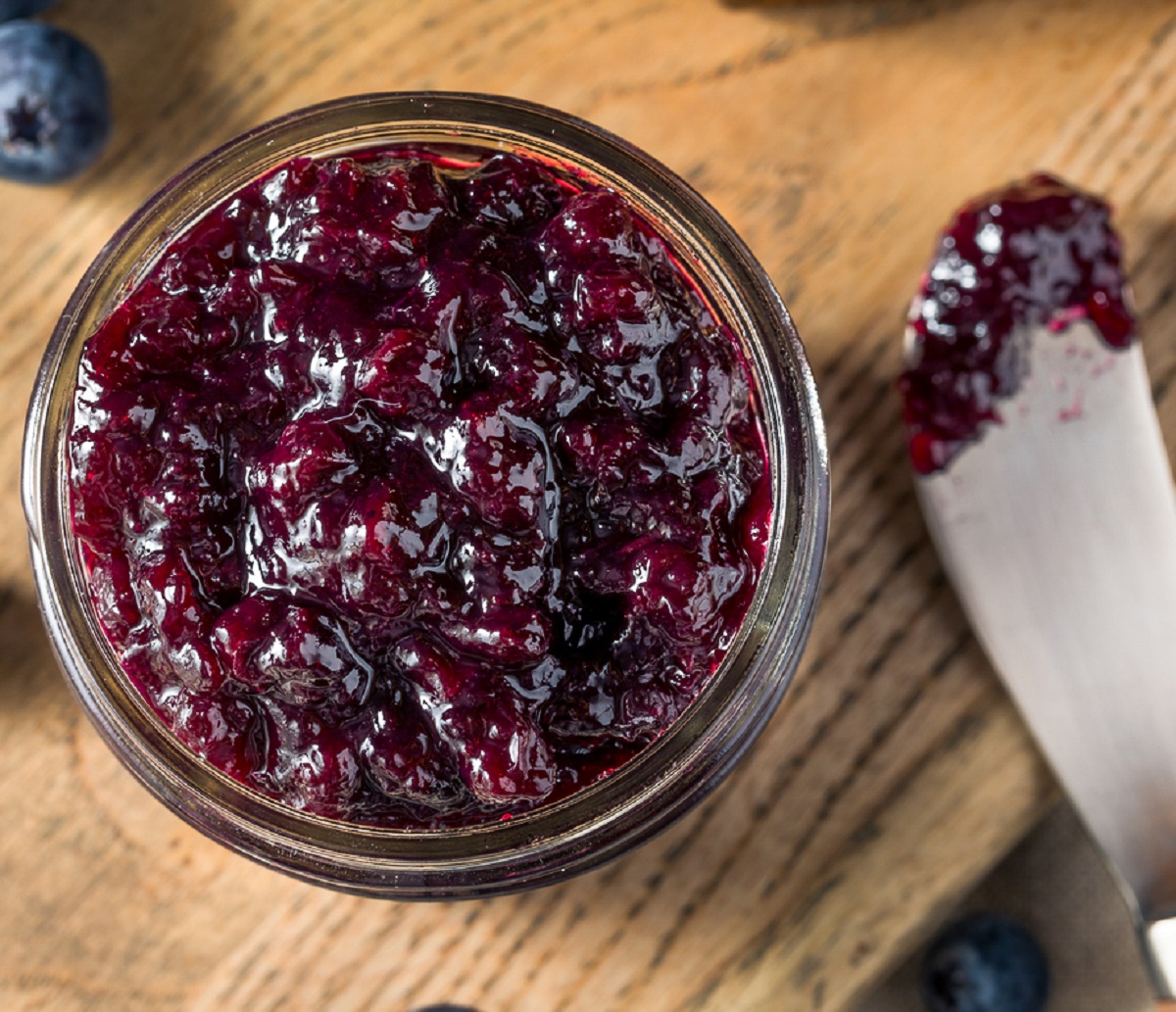 Homemade Blueberry Compote in jar with spreader knife