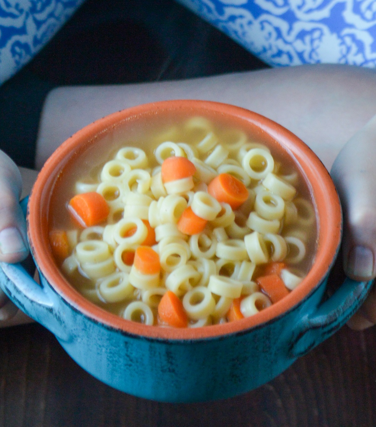 Chicken Noodle Soup Recipe For Kids shown in a blue ceramic bowl. Ditalini noodles and carrots.