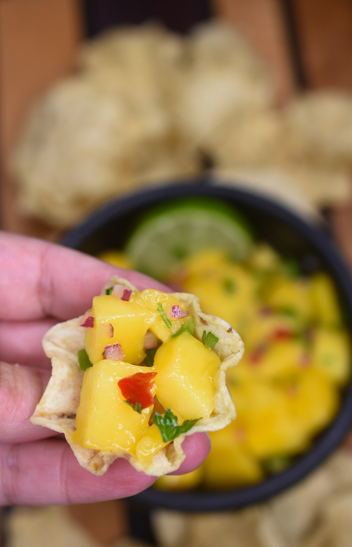 Mango Salsa Recipe, shown scooped up with a tortilla chip