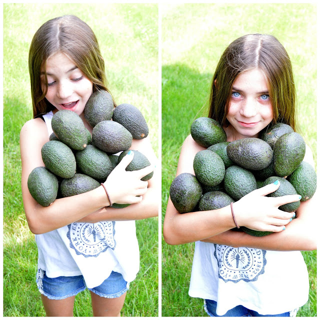 Girl holding a bunch of avocados