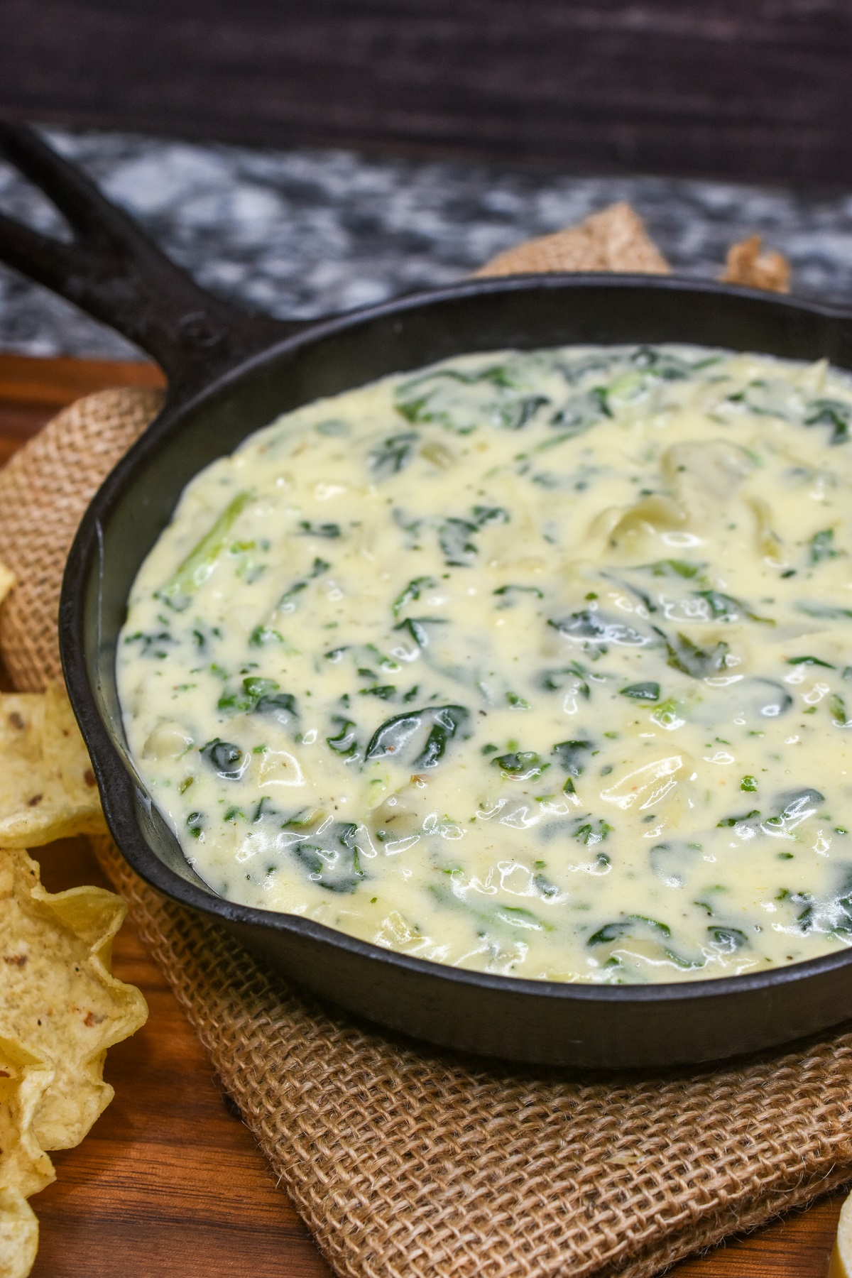 Hot Spinach & Artichoke Dip made stovetop. No may dip. This is just as tasty as ordering it at a restaurant!!  Shown Spinach Artichoke Dip in a small cast iron pan with tortilla chips