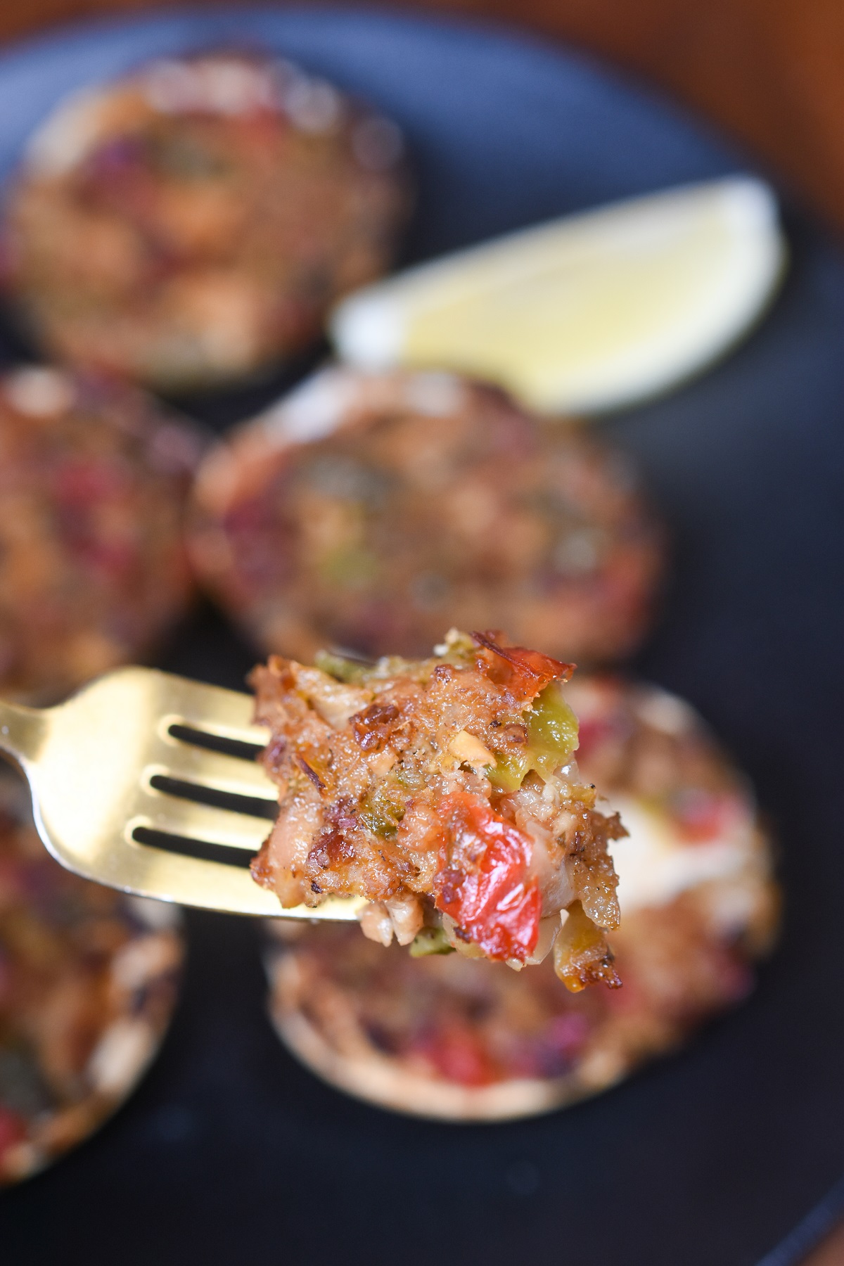 Baked Clams Casino, shown bakes with a fork full of clam stuffing held toward camera
