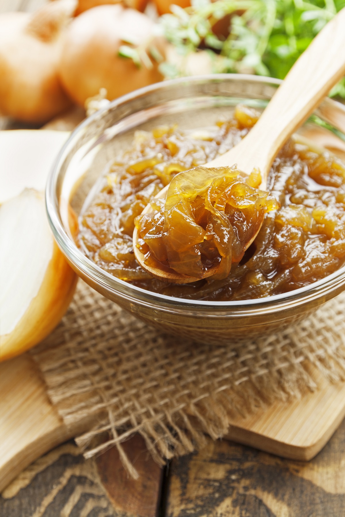 Onion Jam for Lamb Burger. Shown Onion Jam in a glass jar with wooden spoon.