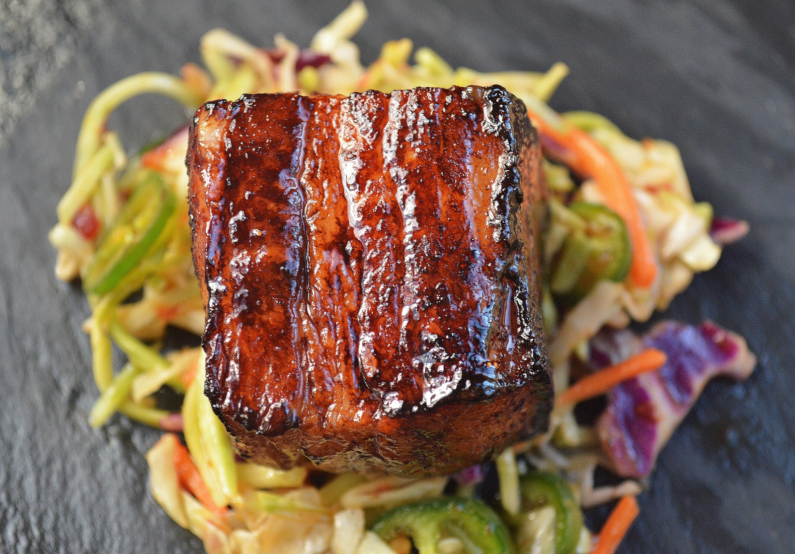 Slow Roasted Pork Belly Bites over Jalapeno Slaw.