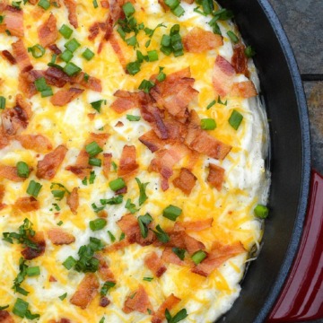 leftover mashed potatoes recipe. Mashed Potato Casserole shown in cast iron pan topped with bacon, scallions and cheese.