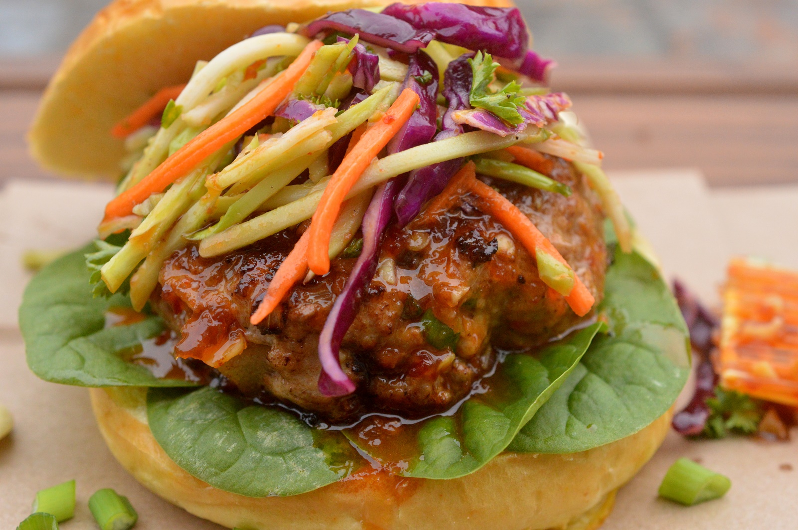 Asian Pork Burgers with Ginger Honey Glaze. Shown Pork Burger on a bun with slaw on a bun.