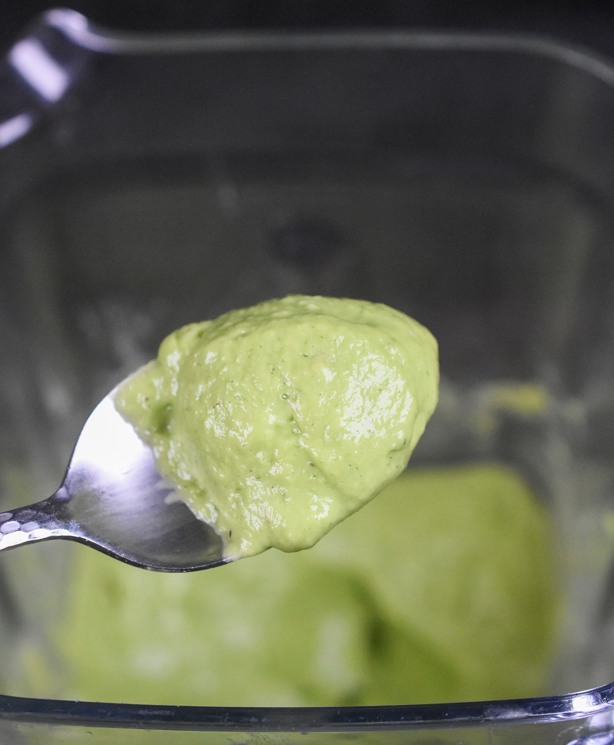 Homemade, no cook Avocado Pasta Sauce. So fresh and delicious! Shown in a blender and on a spoon.