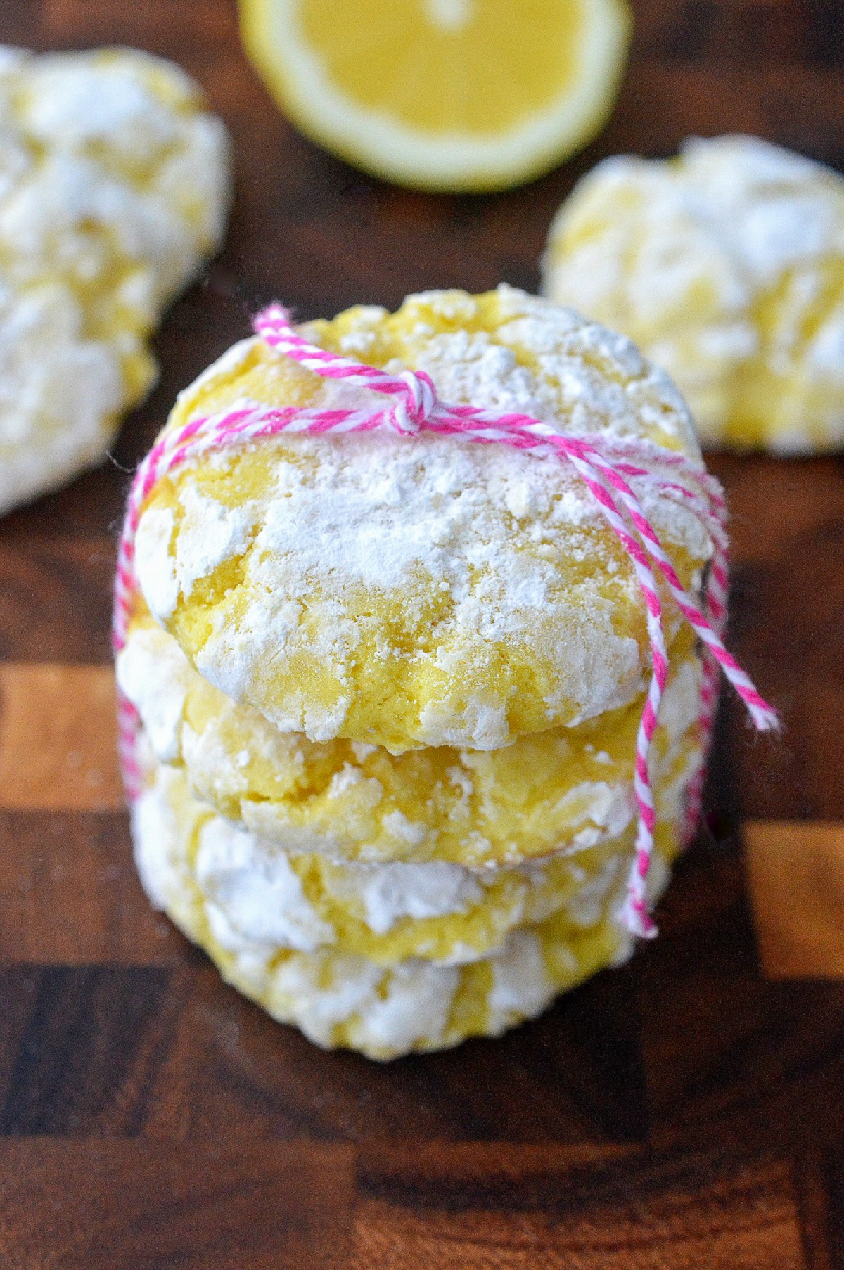 Easy Lemon Crinkle Cookies recipe. A delicious lemon cookie recipe Showl 3 cookies stacked atop one another tied with pink and white bakery string