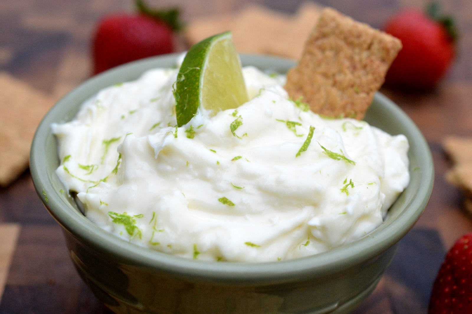 Key Lime Pie Dip in green bowl with a graham cracker.