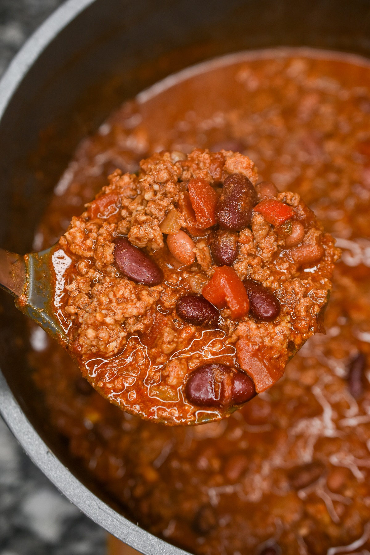 Pot of chili with chili on ladle