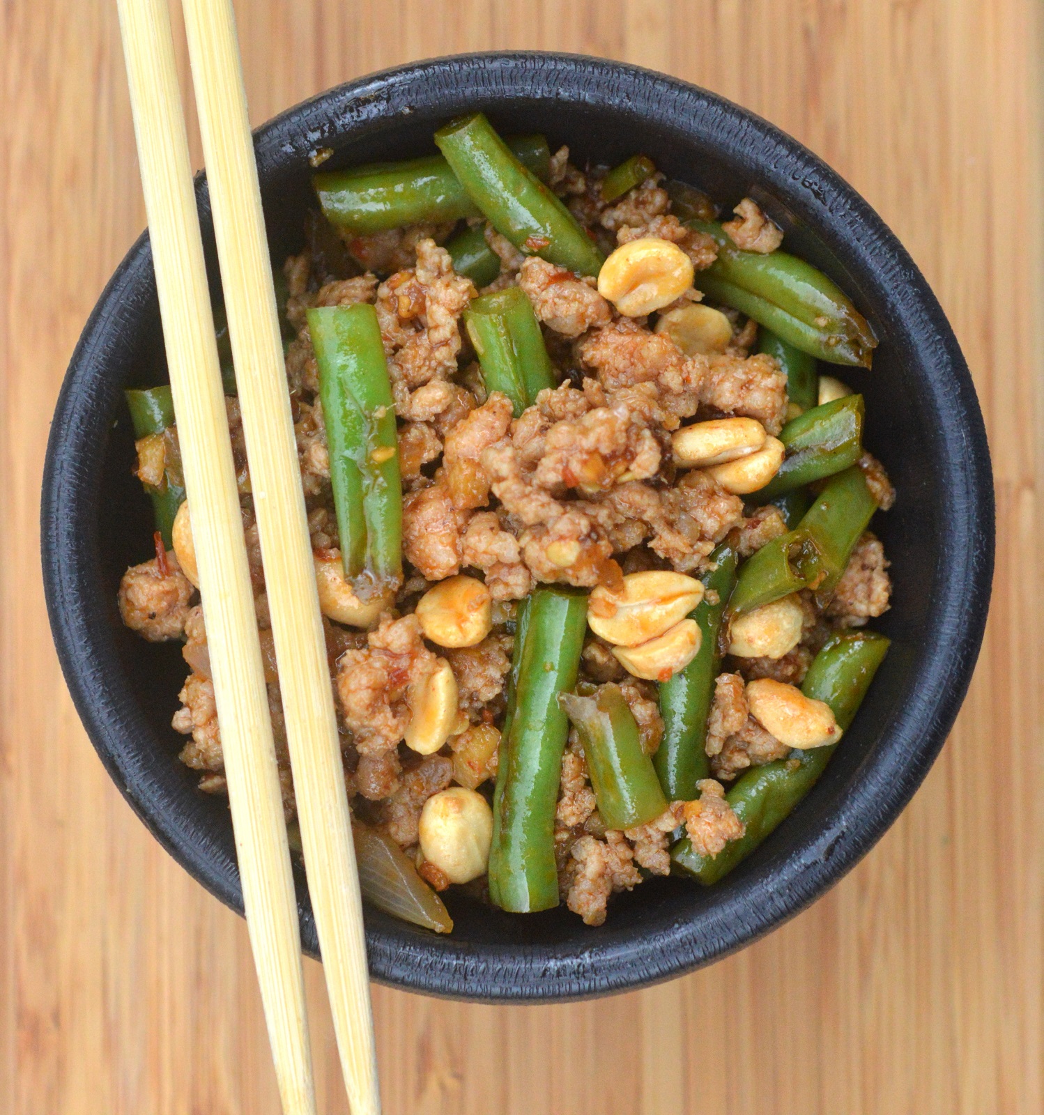 Ground Meat & String Bean Stir Fry recipe with peanuts shown in a black bowl with chopsticks.