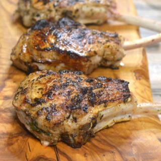 The BEST Grilled Veal Chops Recipe Shown Grilled Veal Chops on a wooden board.