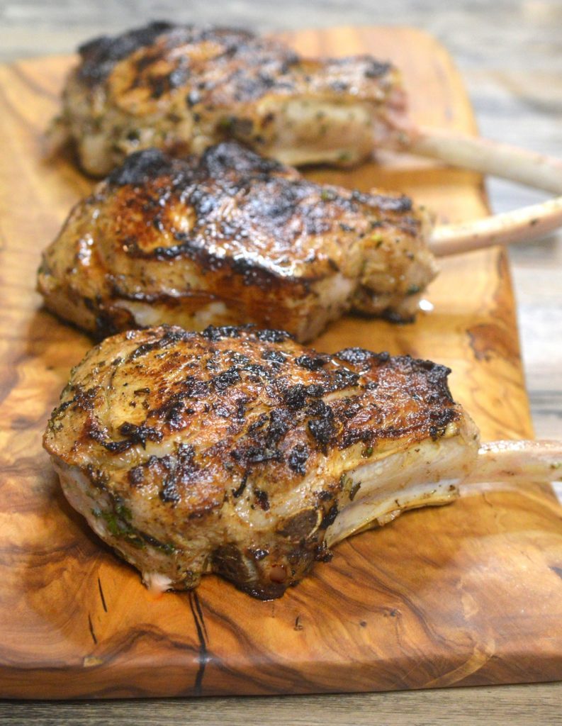 The BEST Grilled Veal Chops on a wooden cutting board. Grill inside or out
