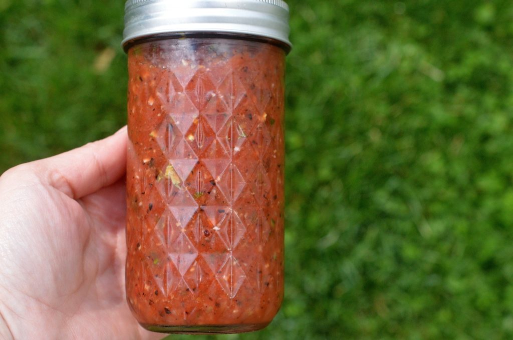 % monite salsa made in a blender shown in a mason jar