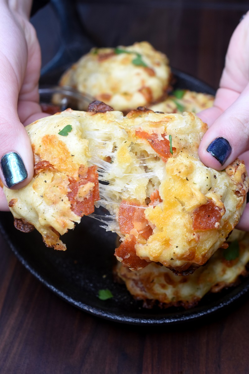 Pepperoni & Cheese Drop Biscuits show pulling one apart with cheese pull. Yum!