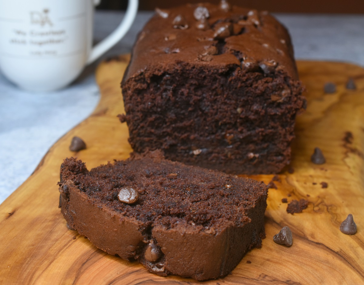 Loaf of Chocolate Banana Bread with a slice cut off on a white plate