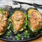 Cooked Grilled Meatloaf Stuffed Peppers on a cast Iron skillet garnished with parsley