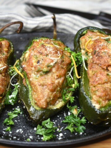 Cooked Grilled Meatloaf Stuffed Peppers on a cast Iron skillet garnished with parsley
