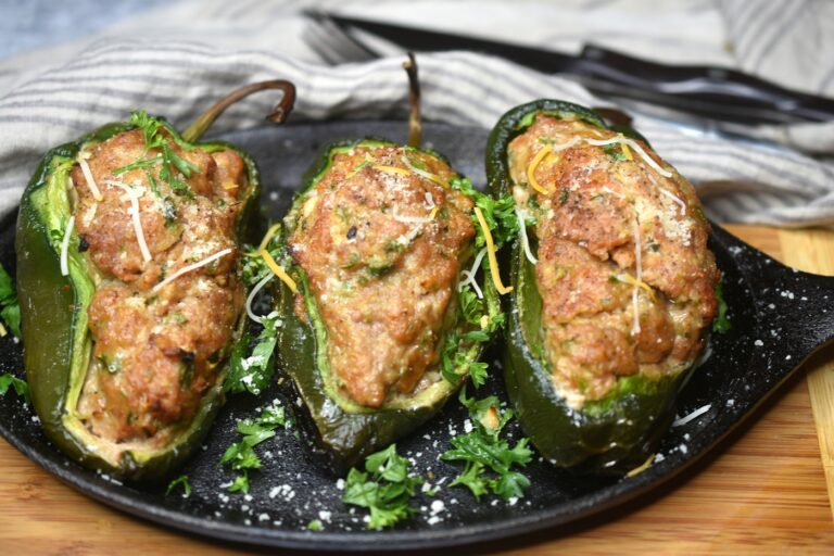 Cooked Grilled Meatloaf Stuffed Peppers on a cast Iron skillet garnished with parsley