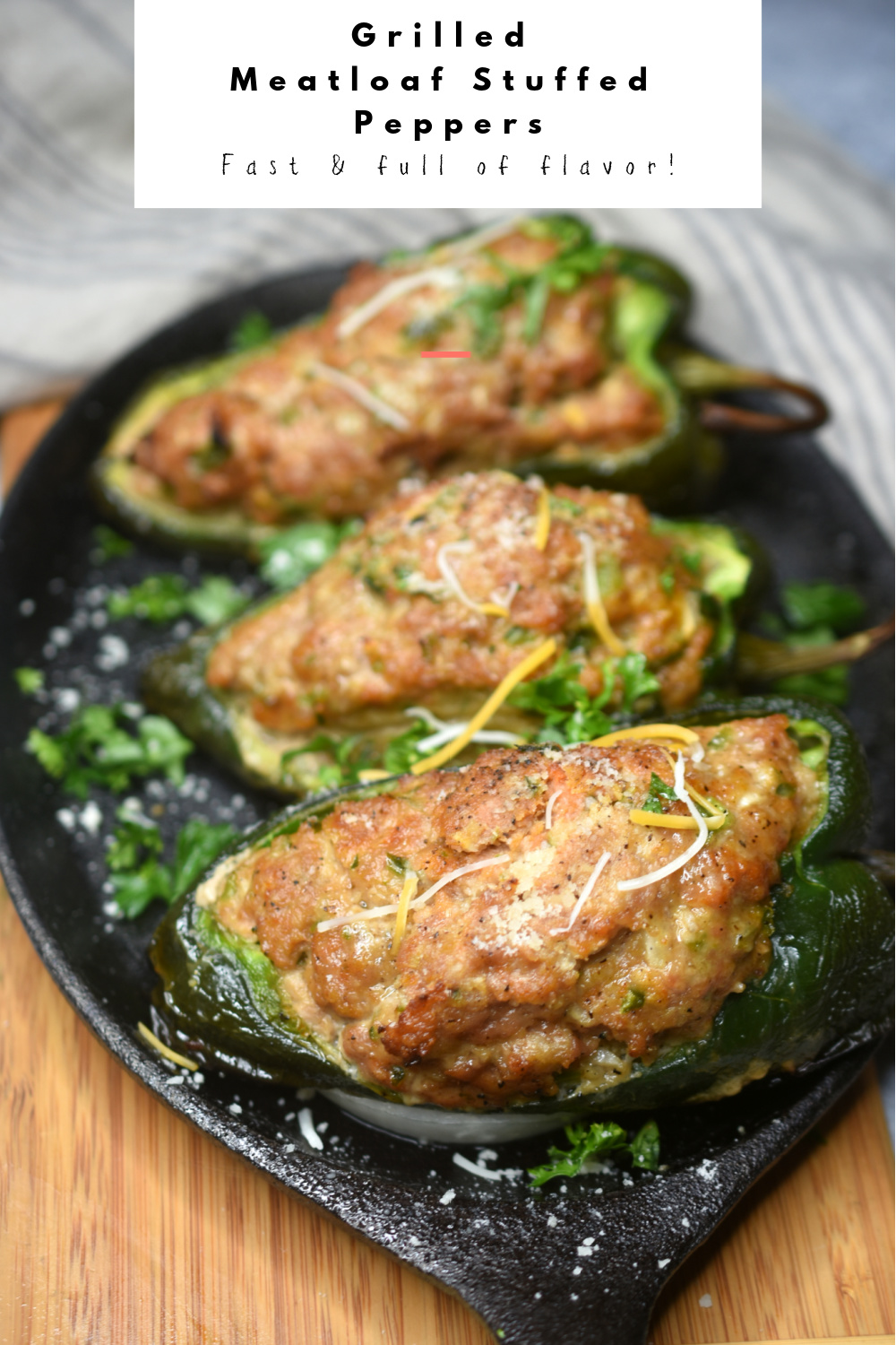 Pinterest image of three cooked Grilled Meatloaf Stuffed Peppers on a cast iron skillet