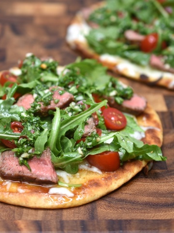 2 Chimichurri Steak Flatbreads on a wooden cutting board