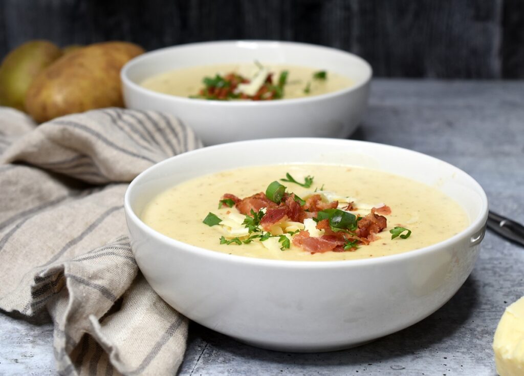 Creamy Potato Soup topped with bacon crumbles in a white bowl