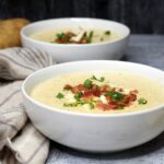 Creamy Potato Soup topped with bacon crumbles in a white bowl