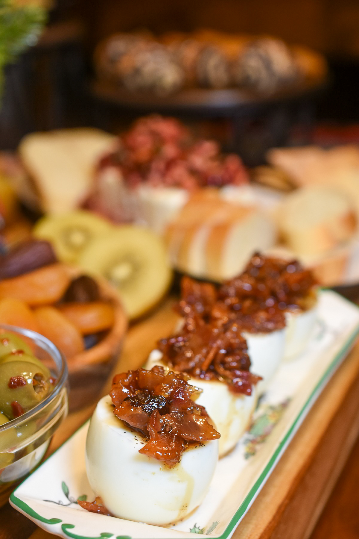 photo of part of a charcuterie board with focus on bacon jam topped hard boiled eggs.