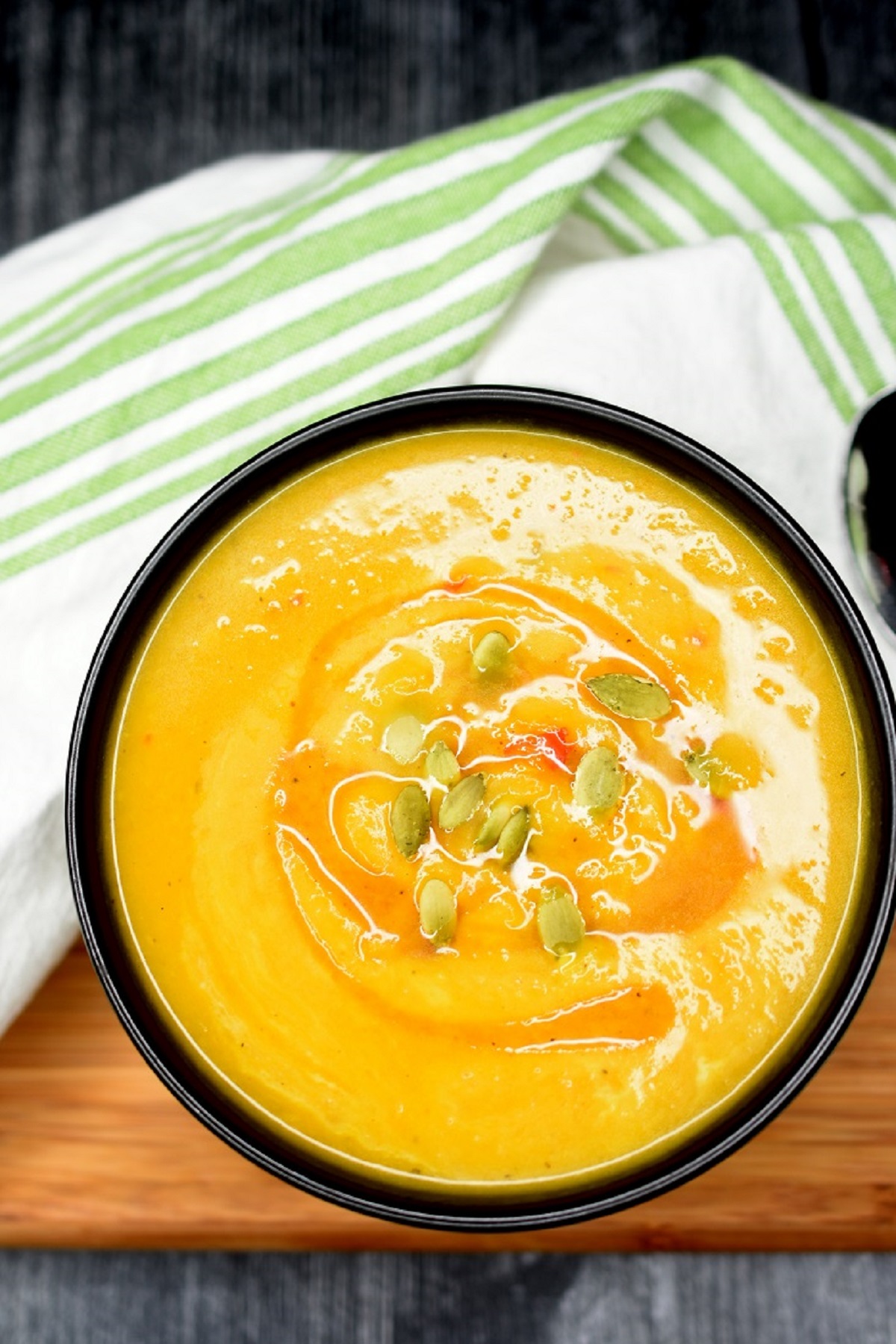 pumpkin soup in a bowl with pepita garnish