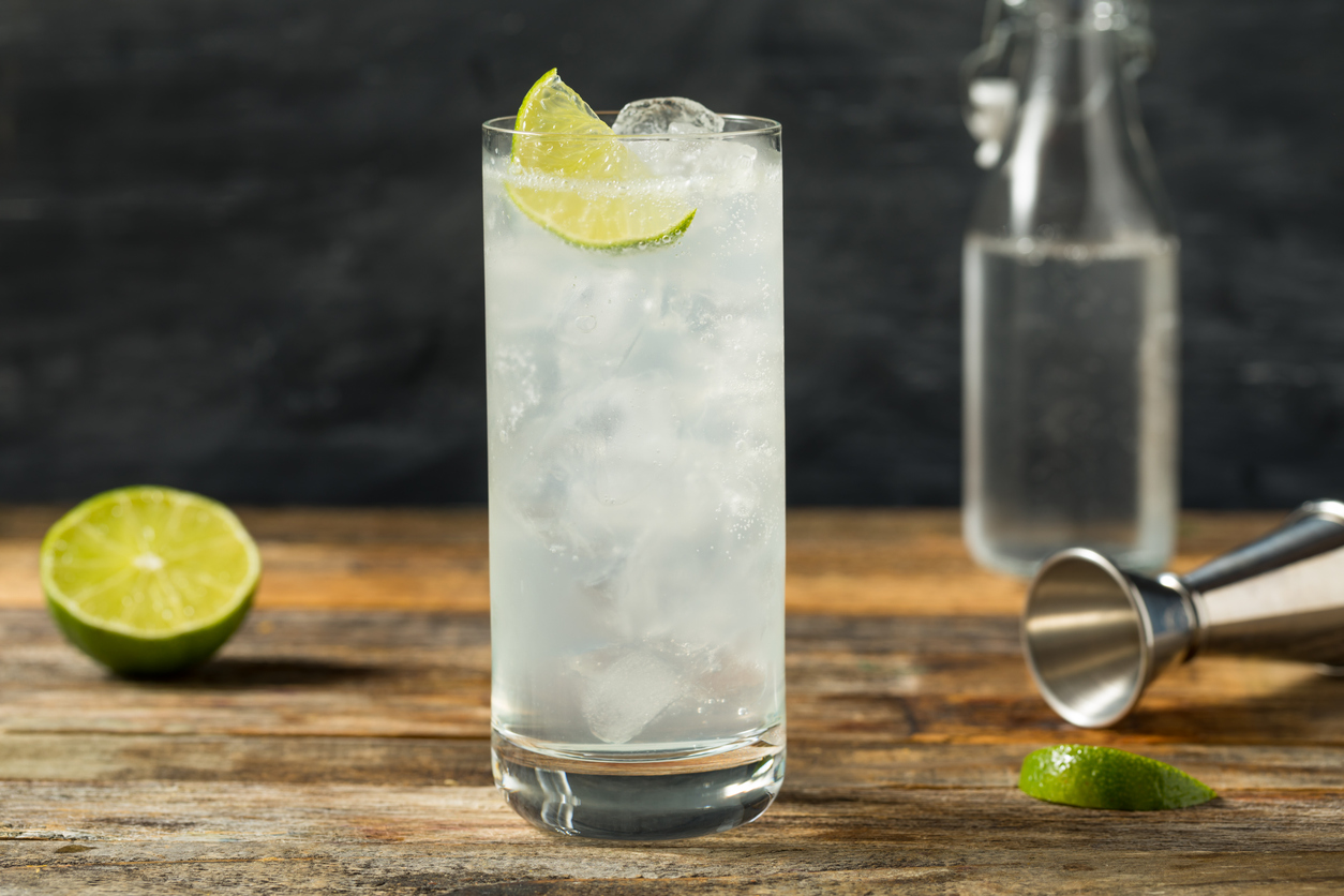 Homemade Lime Soda shown in a tall glass with ice and a lime wedge.