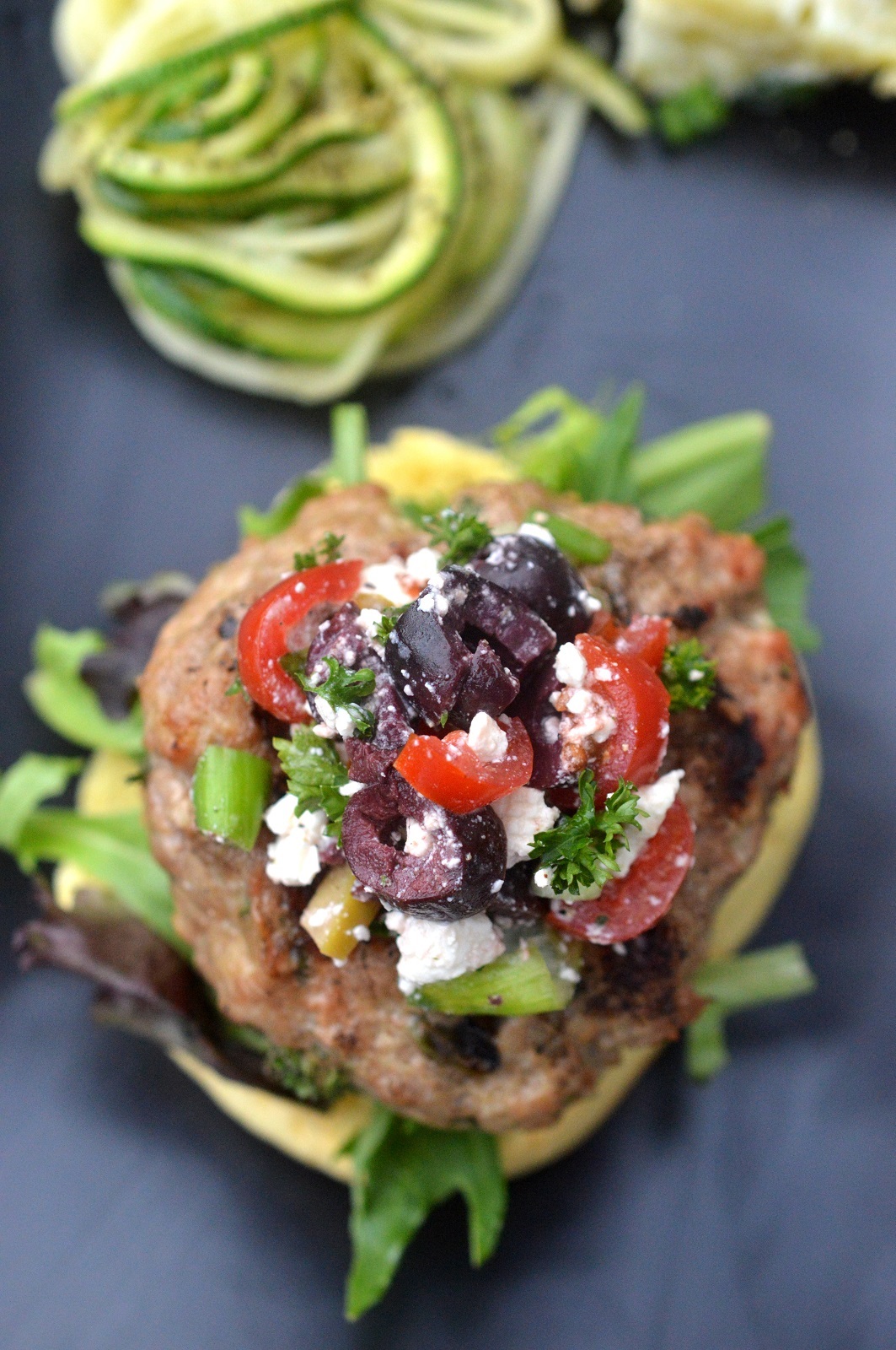 Mediterranean Burgers made with ground veal, topped with feta, tomatoes, olives and more.