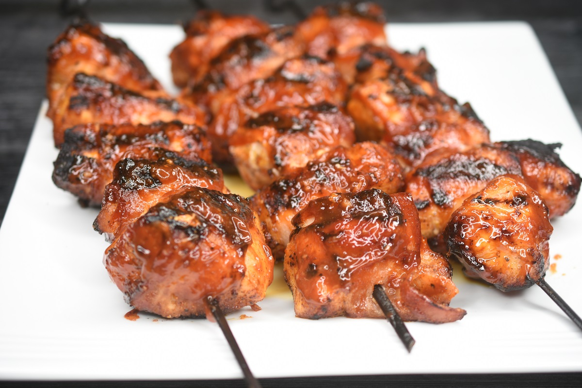 Bacon Wrapped Chicken Skewers basted with BBQ sauce.