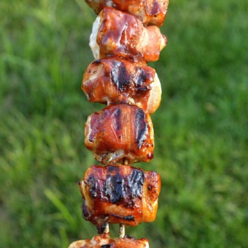 Chicen Wrapped In Bacon with BBQ sauce. Grilled Bacon Wrapped Chicken on a skewer