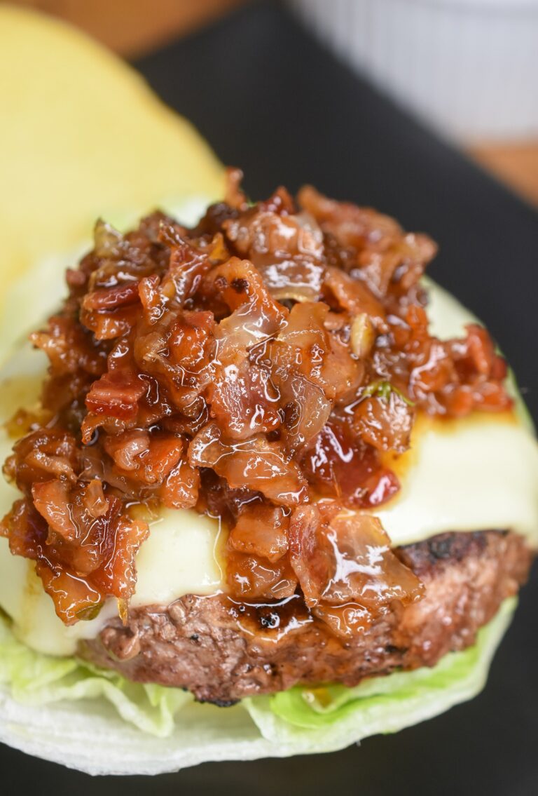 Burger with bacon jam on an open burger bun with lettuce and cheese