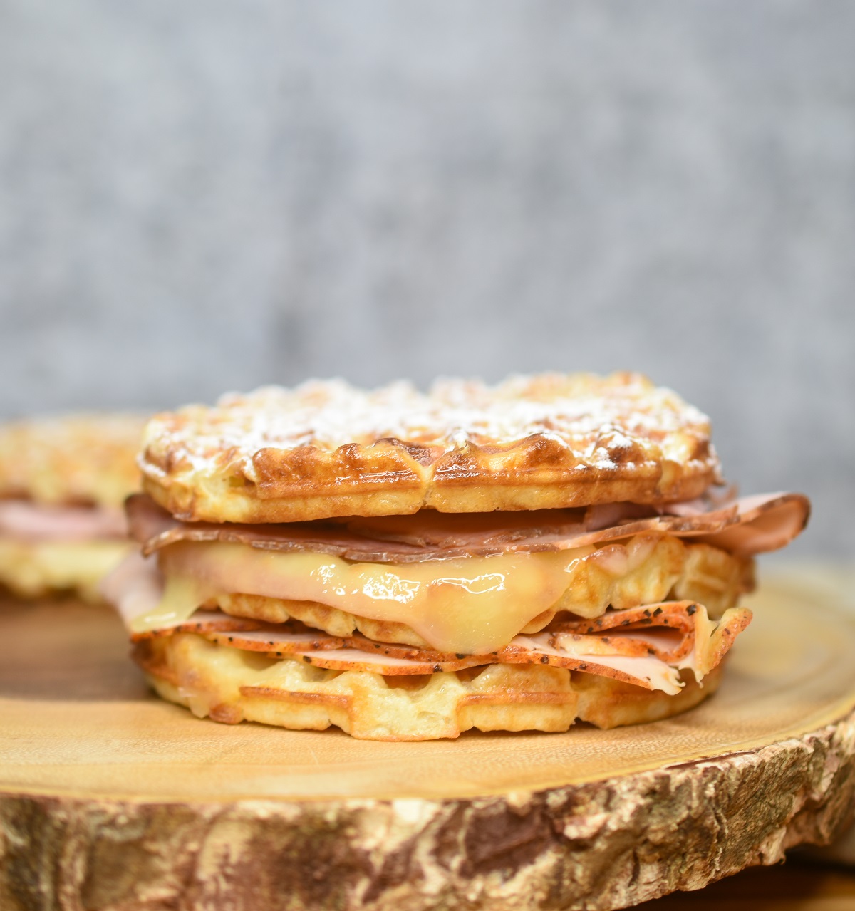 Monte Cristo Waffle Sandwich dusted with powdered sugar with homemade strawberry jam.