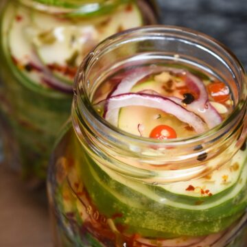 Homemade Pickled Cucumbers in mason jars with red onion.