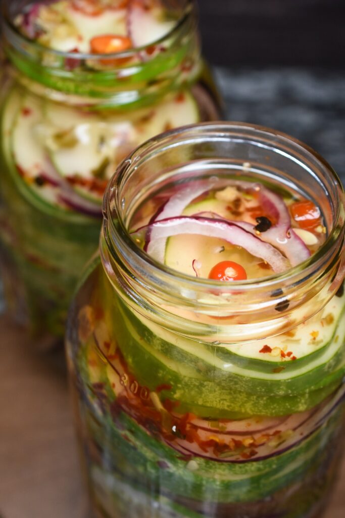 Homemade Pickled Cucumbers in mason jars with red onion.
