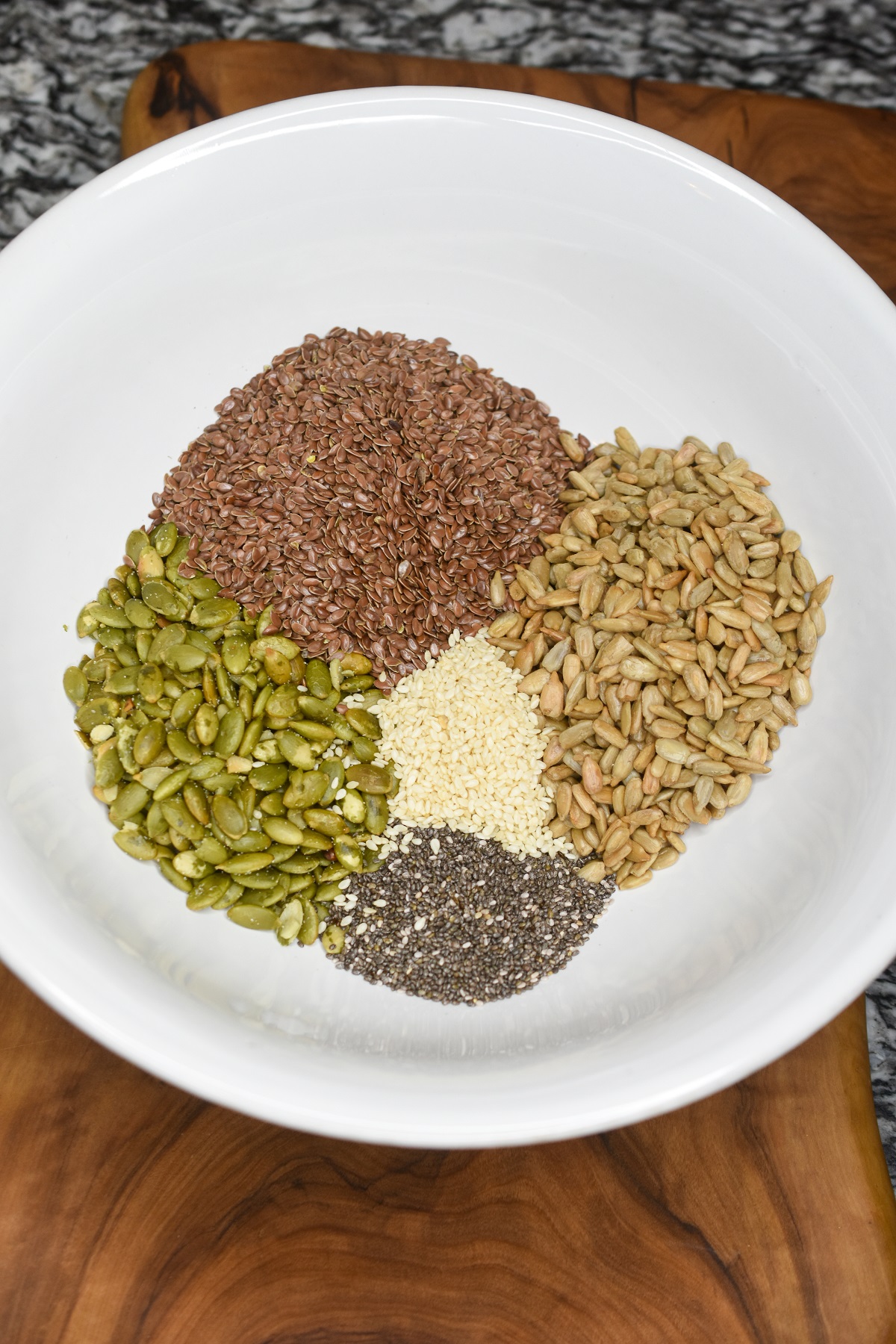 These gluten free homemade Seed Crackers recipe. Seed variety shown in bowl, flax seeds, sesame seeds, pumpkin seeds, sesame seeds and chia seeds.