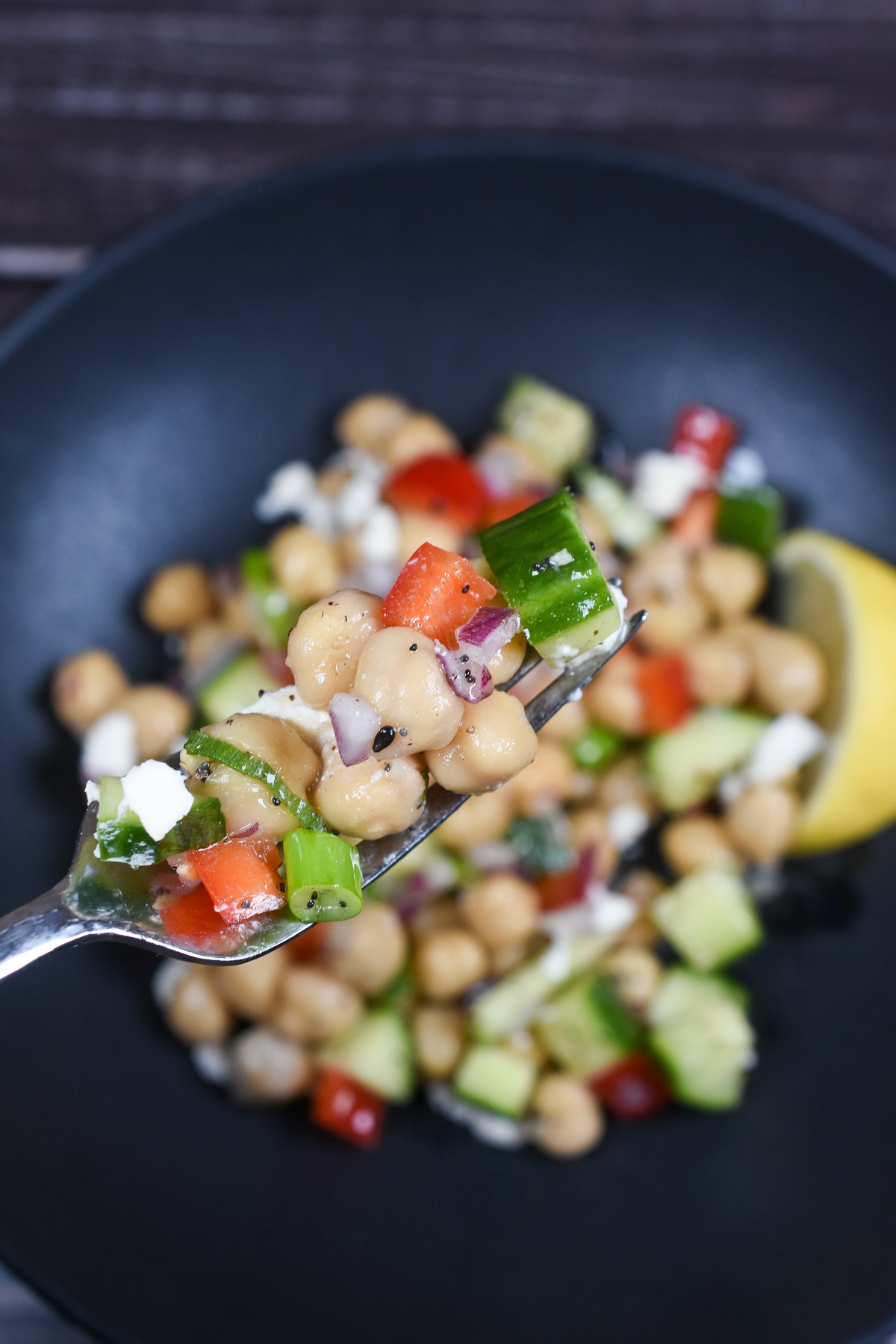 Dense Bean Salad Recipe. You choose the beans, one two or three varieties. This nutrient dense salad is loaded with fiber and protein. It's tasty and it satisfies!  Shown on a black plate with some of the bean salad on a fork.