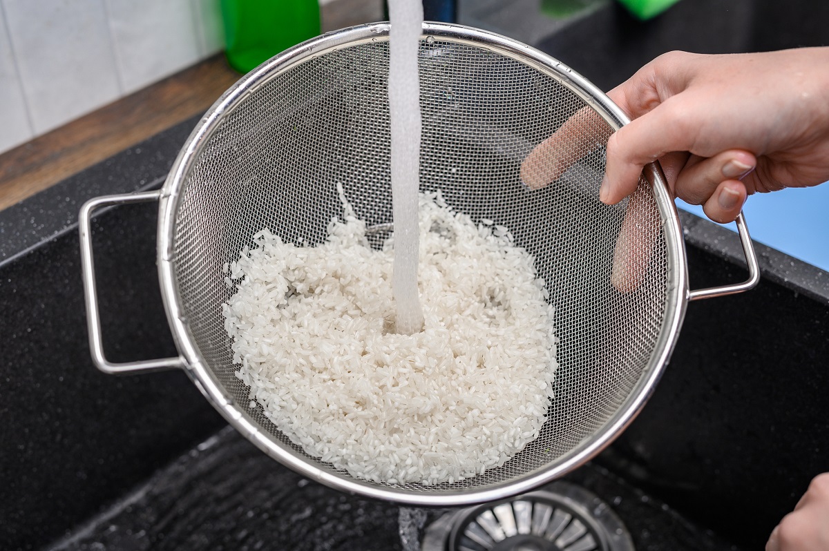 Rinsing uncooked rice in a mesh strainer