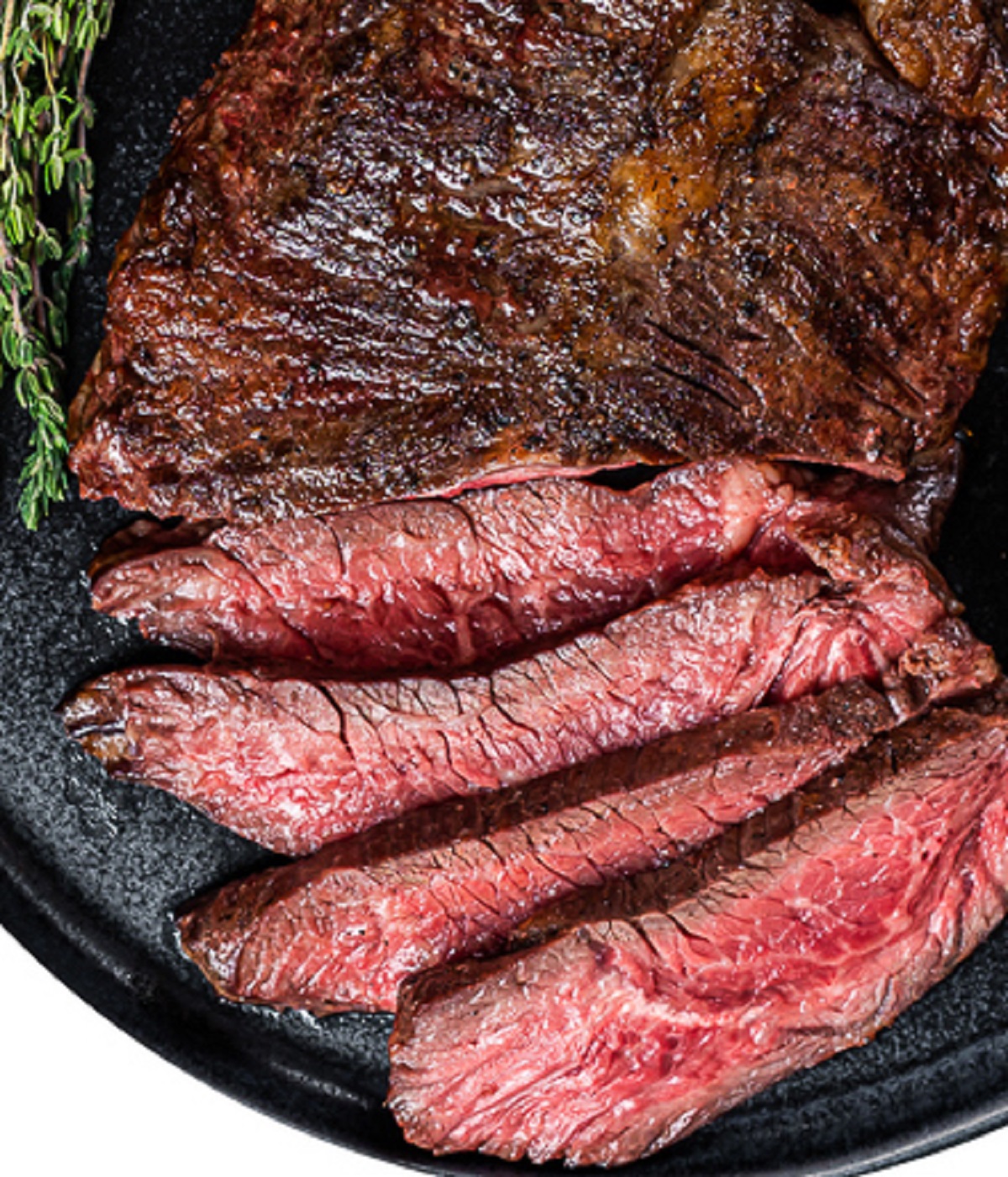 Bavette Steak also known as Flap Steak and Bavette de Boeuf (in France) is a rich, beefy cut of steak prized for its flavor, ease of cooking and price. Shown cooked rare and sliced with a sprig of thyme.