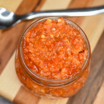 This easy to make Chili Garlic Sauce is the secret of so many delicious recipe! Plus its a great way to use those red jalapeno peppers from the garden! Homemade Chili Garlic Sauce shown in a mason jar