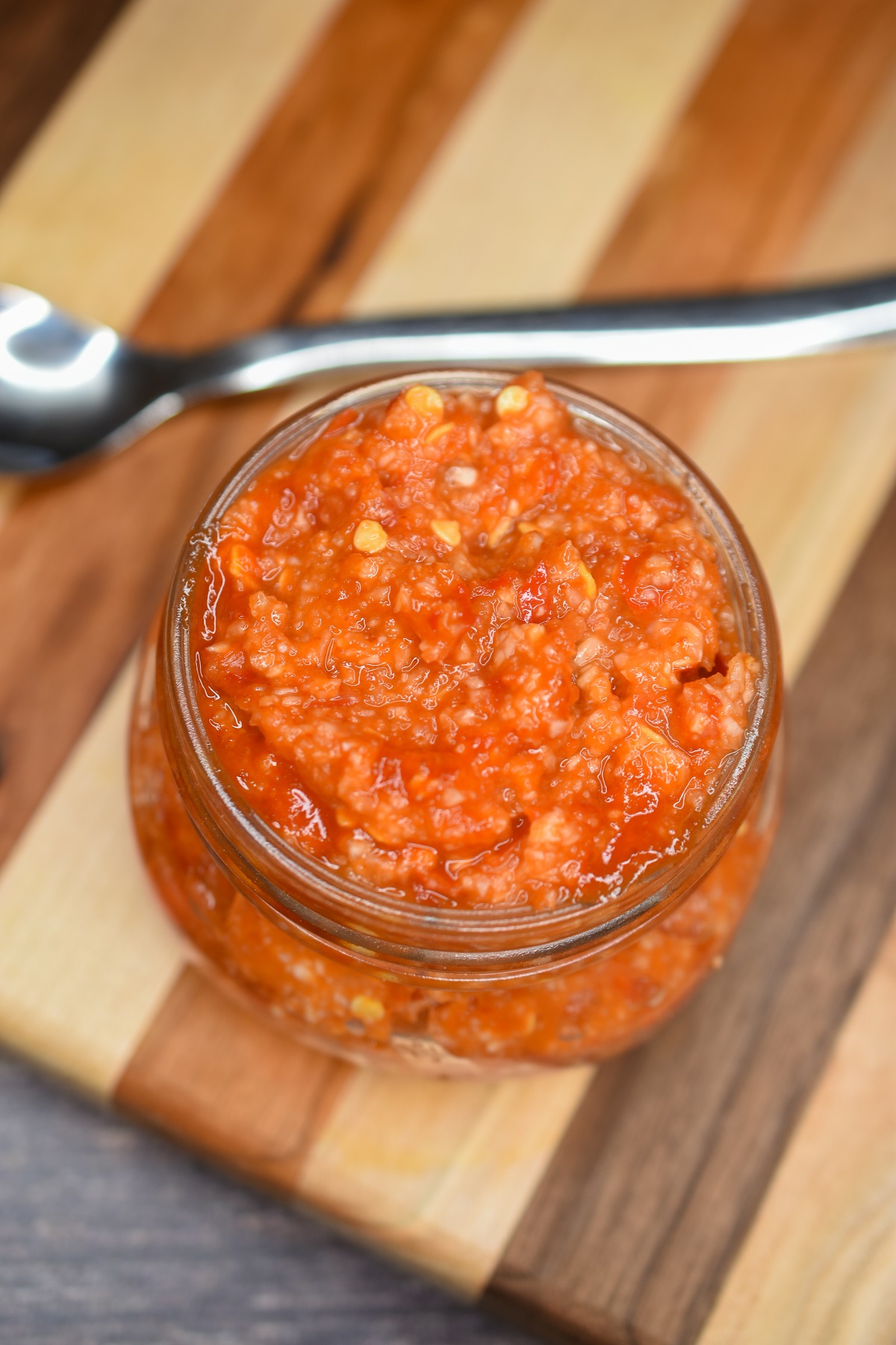 Homemade Chili Garlic Sauce shown in a glass mason jar.