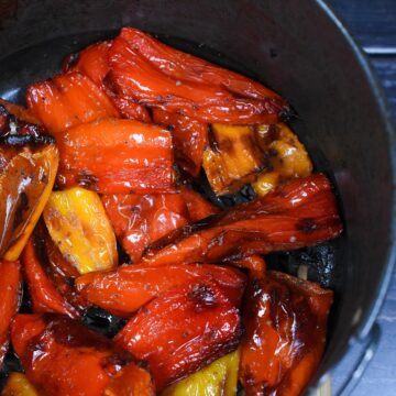 Air Fryer Peppers. Mini Sweet Peppers in Air fryer. red, yellow and orange mini peppers charred from air fryer in cooking basket.