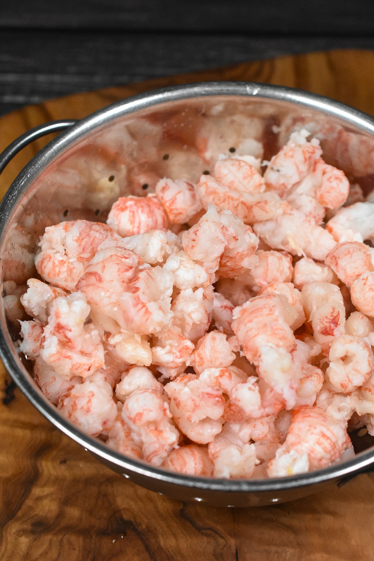 Langostino thawing in a colander being used for making langostino lobster salad.